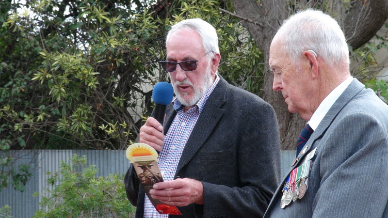 Cr John Neal reads about the special roses from France, planted at the War Memorial