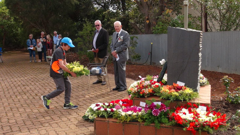 William Schulz lays a wreath on behalf of the Point Pass Tennis Club